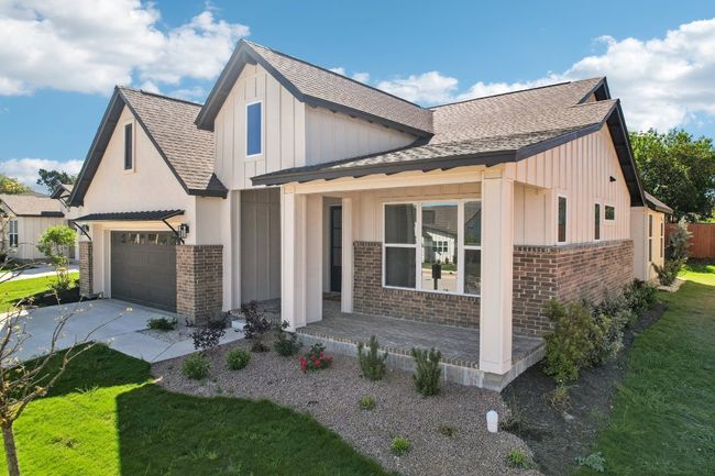 Modern farmhouse featuring a shingled roof, a garage, board and batten siding, concrete driveway, and brick siding | Image 38