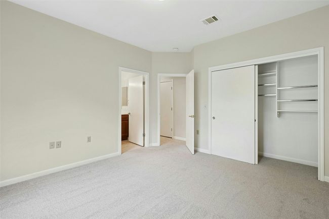Unfurnished bedroom featuring light carpet, baseboards, a closet, and ensuite bathroom | Image 17
