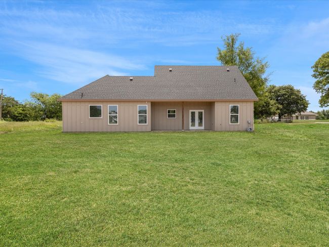Rear view of house featuring french doors, a lawn, and a shingled roof | Image 27