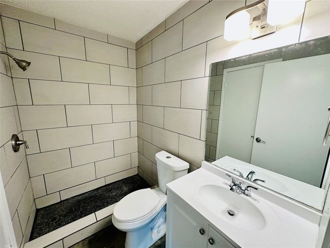Bathroom with vanity, a textured ceiling, and a tile shower | Image 14