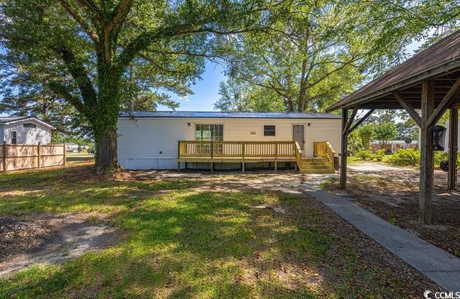 Back of house featuring a wooden deck and metal roof | Image 5
