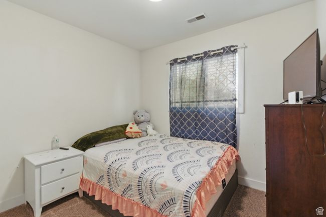 Bedroom featuring baseboards, dark colored carpet, and visible vents | Image 21