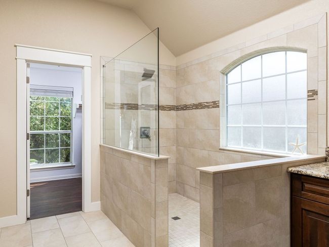 Renovated primary bathroom with extra large walk in shower and double vanities. | Image 15