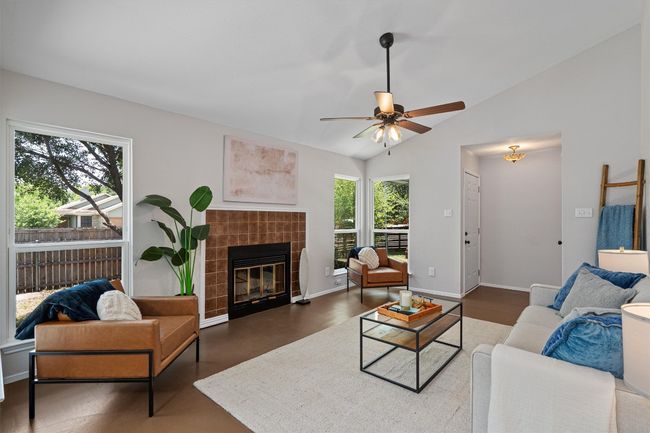 Living room featuring lofted ceiling, a ceiling fan, and a fireplace | Image 4