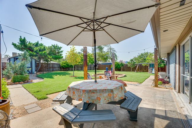 Fenced backyard with a patio area and a playground | Image 30