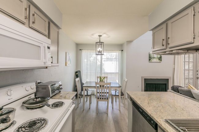 Kitchen with light wood-type flooring, white appliances, gray cabinets, and pendant lighting | Image 7