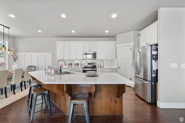 Kitchen featuring appliances with stainless steel finishes, an island with sink, light countertops, white cabinets, and recessed lighting | Image 8