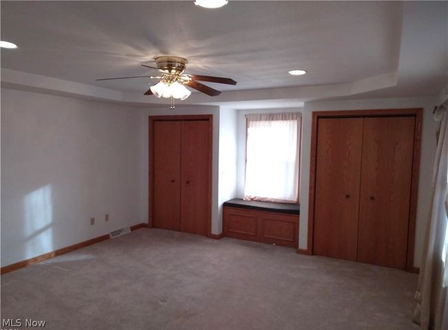 Unfurnished bedroom featuring ceiling fan, carpet floors, and multiple closets | Image 12