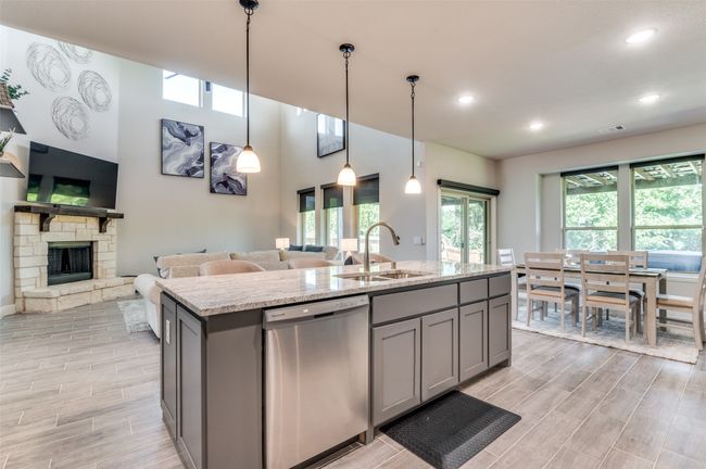 Kitchen with gray cabinetry, stainless steel dishwasher, open floor plan, a kitchen island with sink, and recessed lighting | Image 14