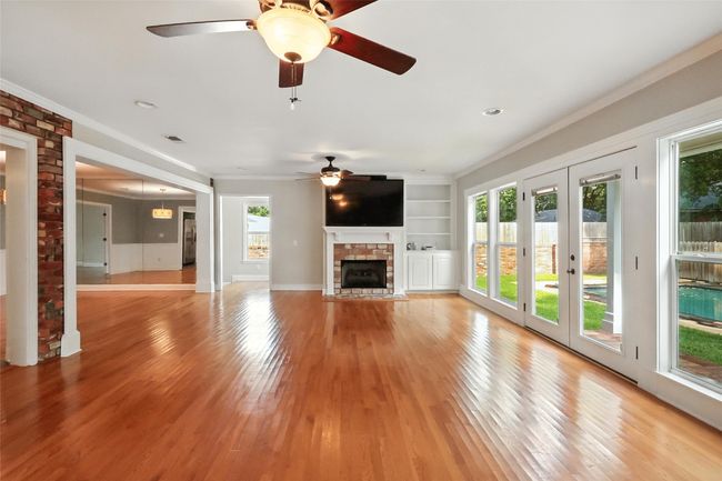 Ranch-style home featuring a garage, brick siding, a shingled roof, concrete driveway, and a front yard | Image 4