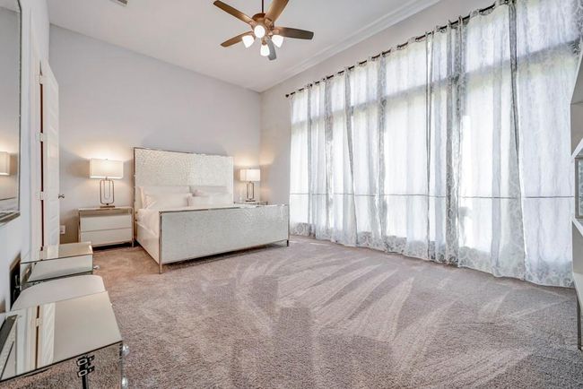 12ft. ceiling in this beautiful primary bedroom. Wall of windows allows for natural light and backyard views. Soft and soothing color palette. | Image 16