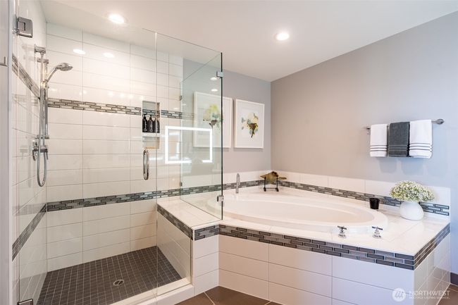 Spa like 5-piece, primary bath boasts of a large walk-in shower and generous size soak tub surrounded by custom tile. | Image 11