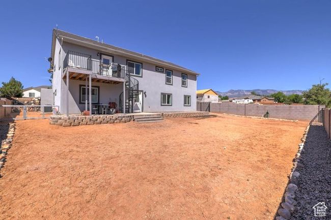 Rear view of property featuring a deck with mountain view, a fenced backyard, stairs, and stucco siding | Image 29