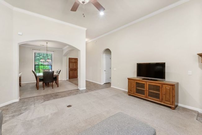Living room featuring arched walkways, crown molding, light colored carpet, and ceiling fan | Image 9