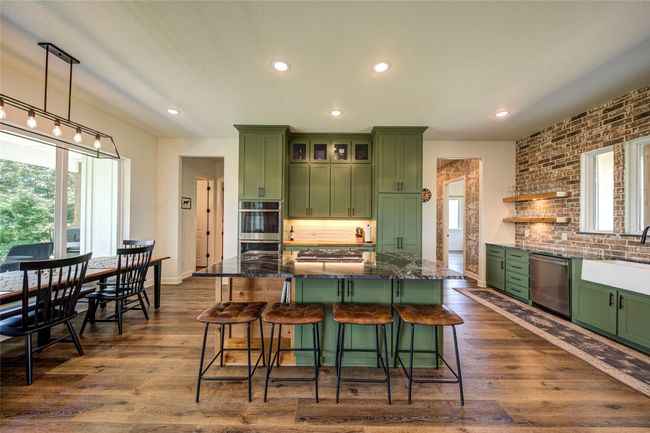 Kitchen featuring a center island, green cabinetry, stainless steel appliances, and a wealth of natural light | Image 7