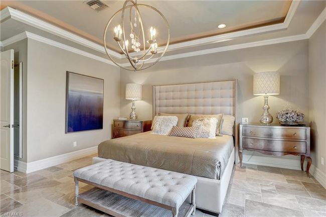 Bedroom with visible vents, ornamental molding, an inviting chandelier, and a tray ceiling | Image 28