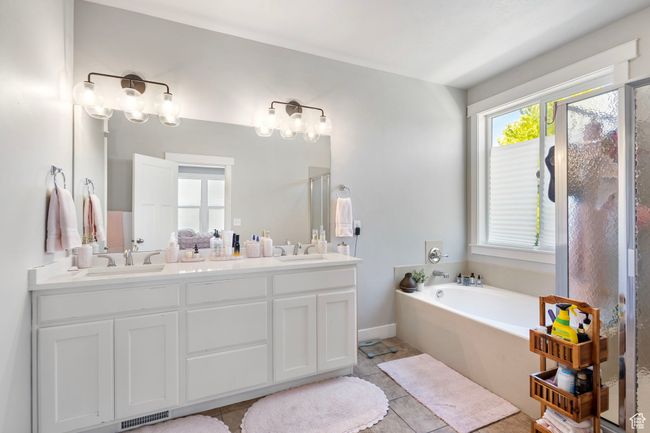 Bathroom featuring a garden tub, double vanity, tile patterned floors, and a shower | Image 20