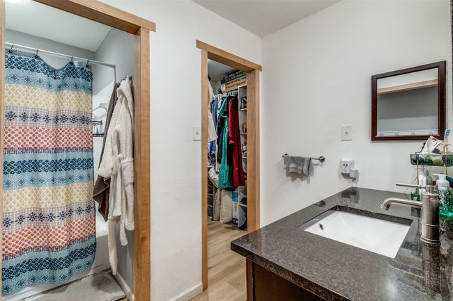 Bathroom featuring curtained shower, wood finished floors, a spacious closet, and vanity | Image 15