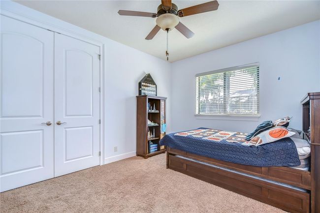 This inviting bedroom features plush carpeting and ample natural light, thanks to the large window with serene views. | Image 25
