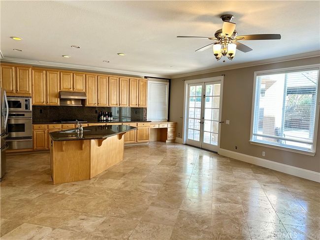 Large family room with lots of windows overlooks large backyard. | Image 4