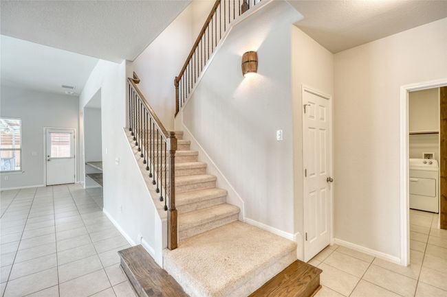 Stairway with baseboards, washer / clothes dryer, a textured ceiling, and tile patterned flooring | Image 23