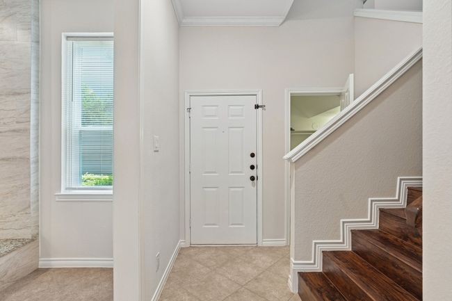 Entryway featuring ornamental molding, tile patterned floors, and stairs | Image 4
