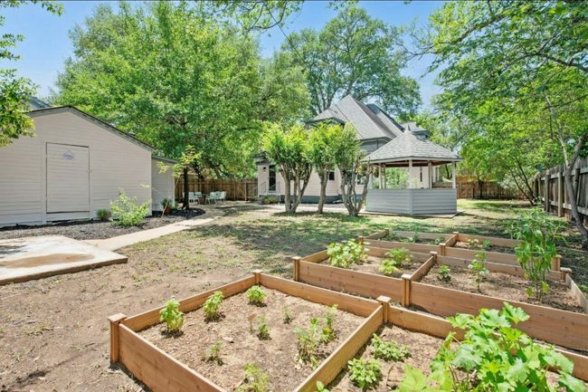 Fenced backyard with a gazebo, active gardens, and an outdoor structure | Image 34