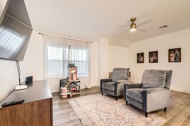 Sitting room with a ceiling fan, light wood-style flooring, and vaulted ceiling | Image 24
