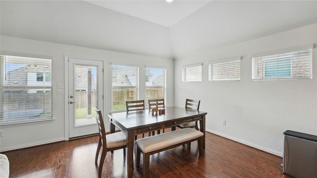 Dining room featuring vaulted ceiling and dark wood finished floors | Image 8