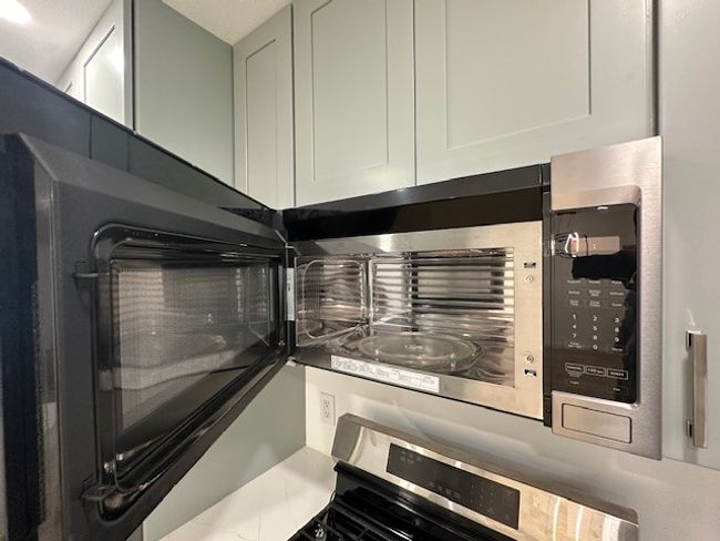 Kitchen view of range and white cabinetry | Image 12