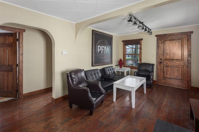 Living room featuring crown molding, arched walkways, hardwood / wood-style flooring, and baseboards | Image 9