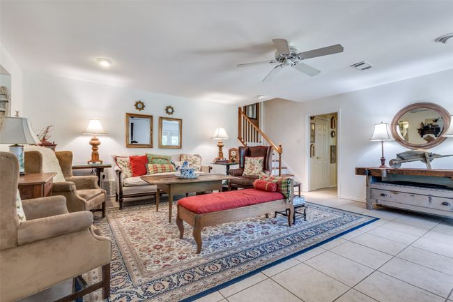 Living room featuring stairs, ceiling fan, light tile patterned floors, and baseboards | Image 12