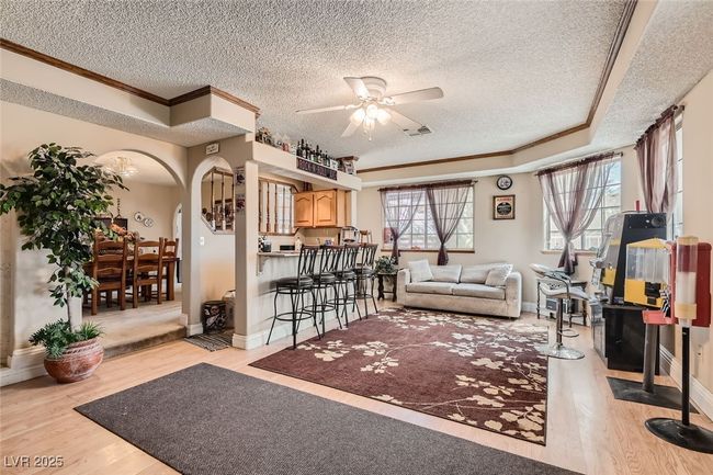 Living room with plenty of natural light, visible vents, arched walkways, and light wood-style floors | Image 14