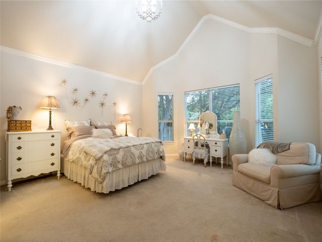 Bedroom with light colored carpet, high vaulted ceiling, ornamental molding and great windows. | Image 13