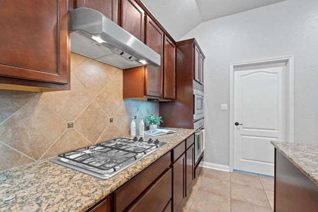 Kitchen with under cabinet range hood, stainless steel appliances | Image 17