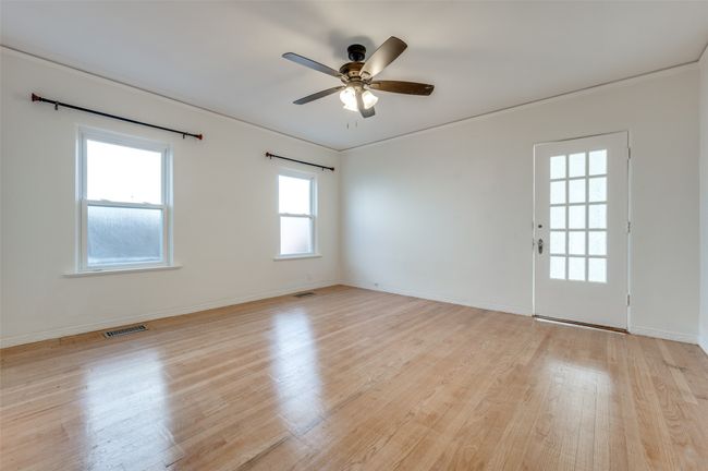 Empty room with a ceiling fan, light wood-type flooring, and baseboards | Image 24