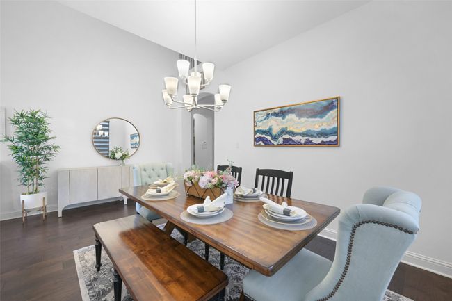 Dining room with dark wood finished floors, baseboards, and a notable chandelier | Image 7