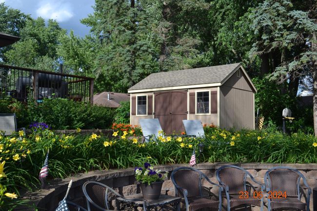 Expansive perennial gardens and shed overlooking the entertaining built-in firepit | Image 52