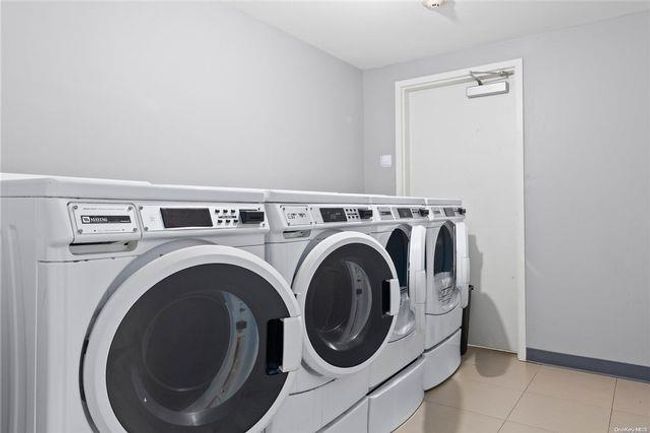 Laundry room featuring washer and dryer and light tile patterned floors | Image 8