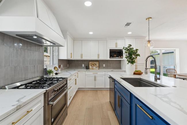 Featuring custom-built cabinetry, Zellige tile, stainless steel appliances, and quartz countertops. | Image 11
