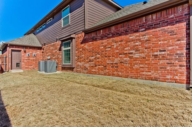 Back of house with brick siding, a lawn, and a shingled roof | Image 35