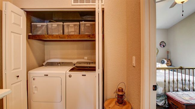 Laundry room with washing machine and clothes dryer, ceiling fan, and a textured wall | Image 19