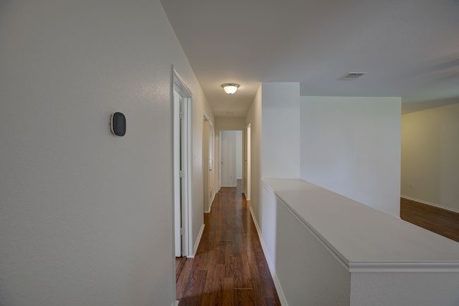 Hallway featuring dark wood-style flooring and baseboards | Image 25