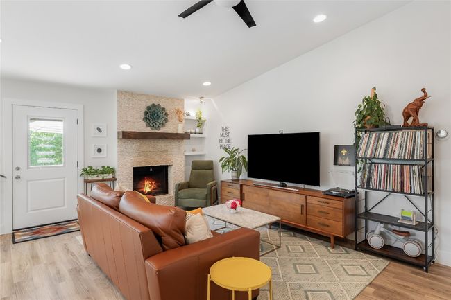 Spacious living area features vaulted ceilings and cozy fireplace. | Image 11