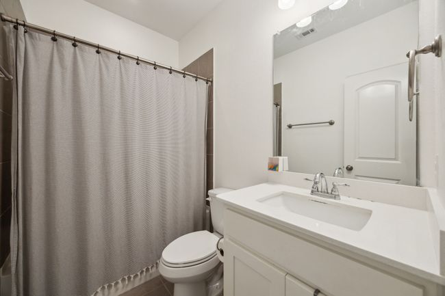 Full bathroom with visible vents, toilet, curtained shower, and vanity | Image 21