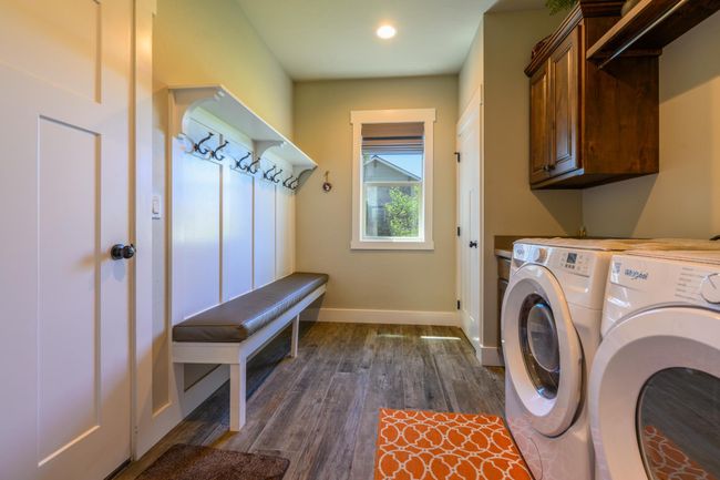 Laundry room featuring cabinet space, independent washer and dryer, dark wood-type flooring, and recessed lighting | Image 17