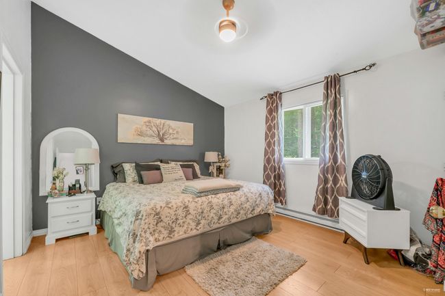 Bedroom featuring vaulted ceiling, light wood-style flooring, and a baseboard heating unit | Image 25