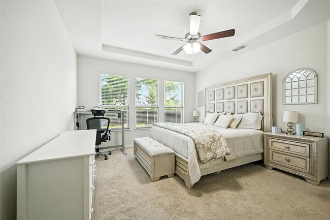 Bedroom with a tray ceiling, light carpet, a desk, and ceiling fan | Image 16