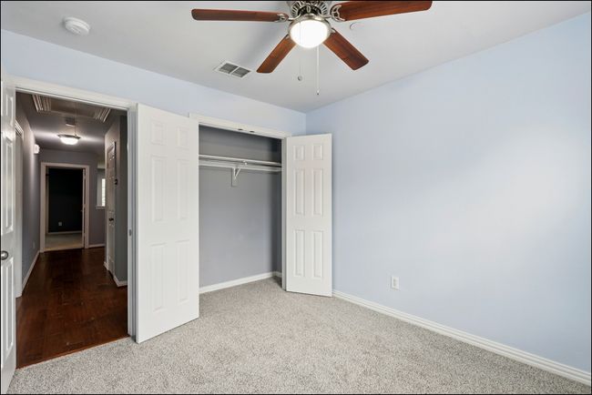 Unfurnished bedroom with attic access, visible vents, baseboards, a closet, and carpet | Image 27