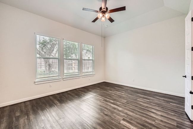 Unfurnished room featuring ceiling fan, dark wood-type flooring, baseboards, and vaulted ceiling | Image 13